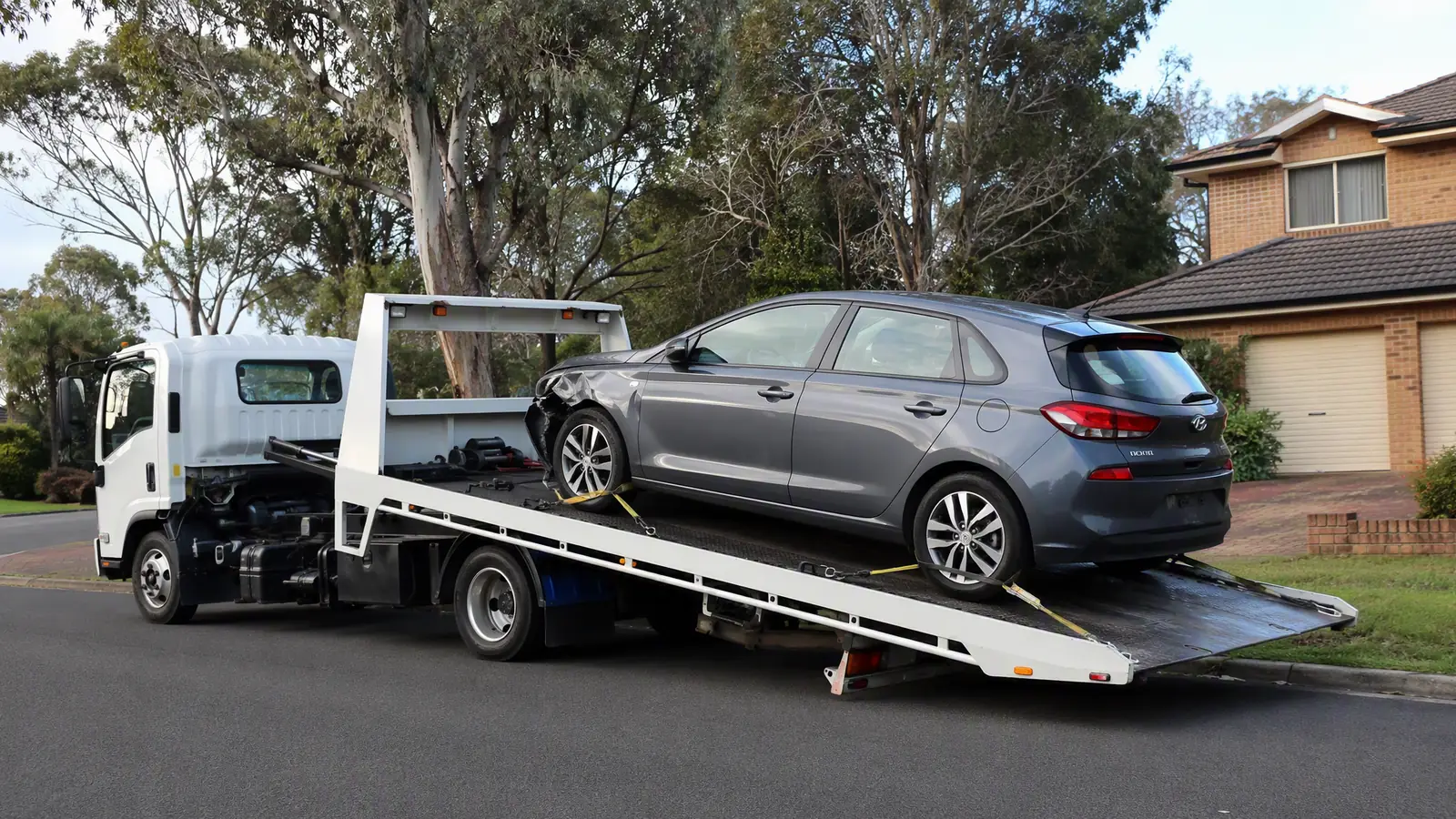 Tilt-tray tow truck loading a car for same-day removal in Sydney